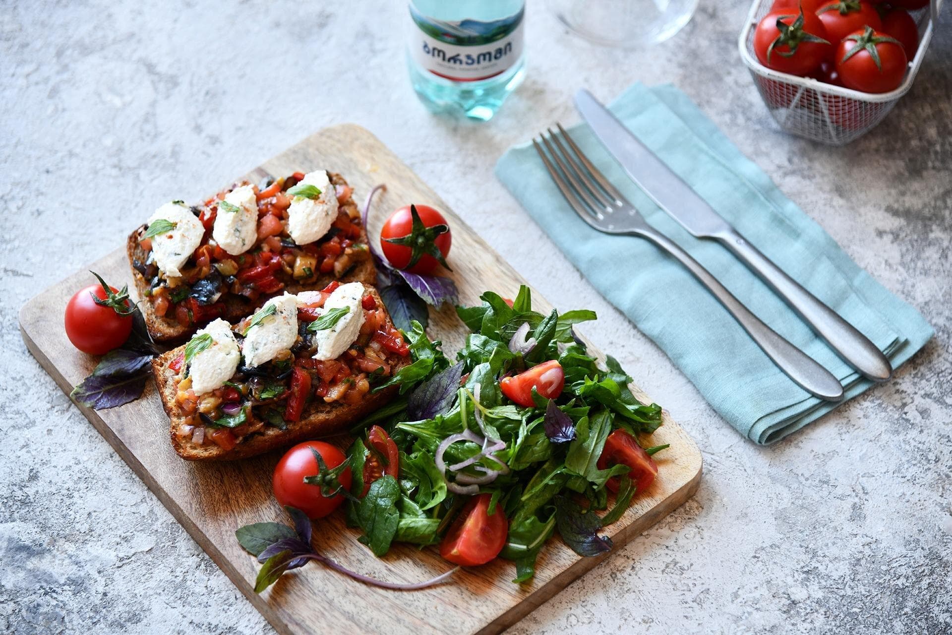 Bruschetta with black bread and wild rocket 